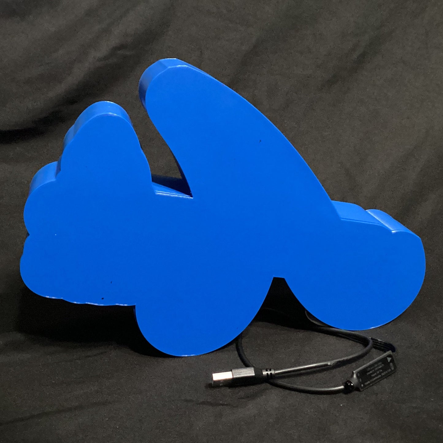 Blue plastic object with a cable on a black background