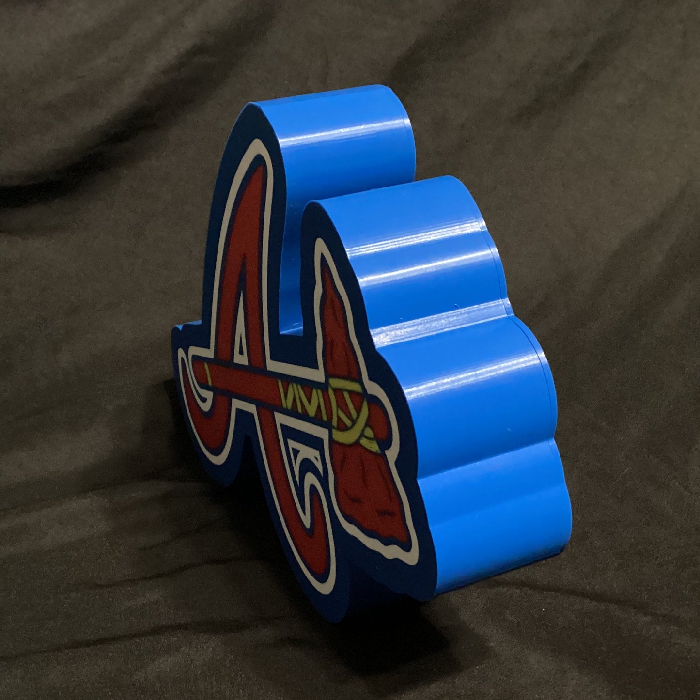 Blue and red logo on a dark fabric background