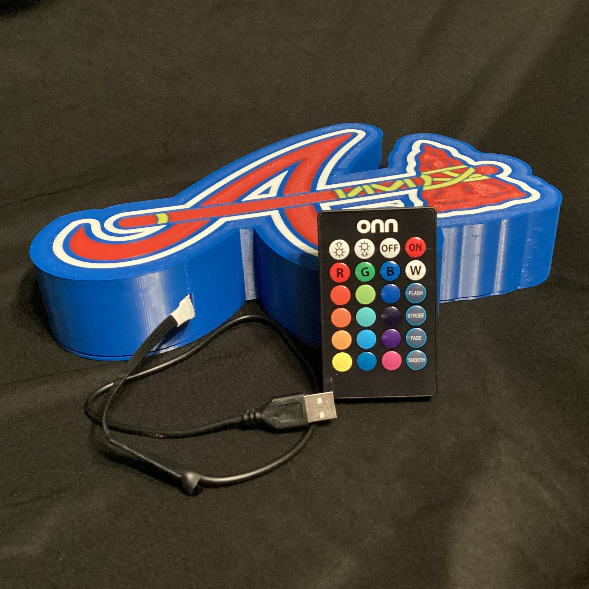 Colorful LED letter 'A' with remote control on a dark background